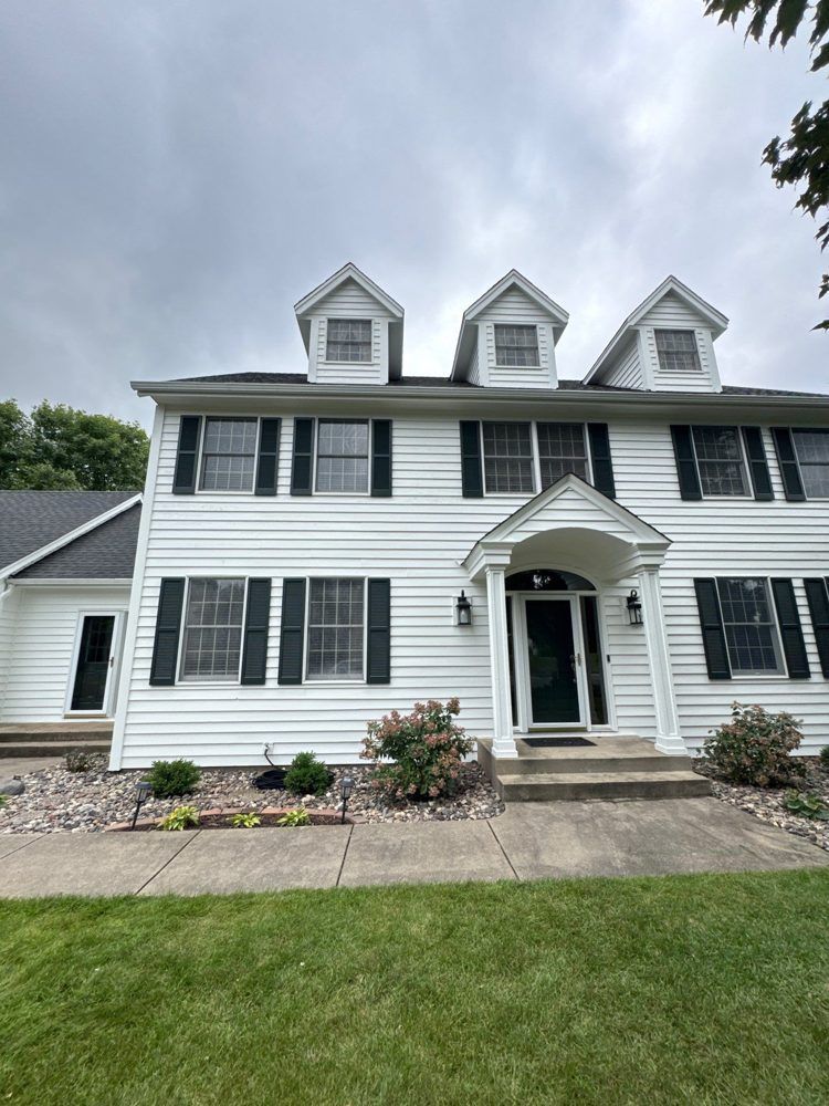 White colonial home with a fresh exterior repaint by The Hillcrest Company